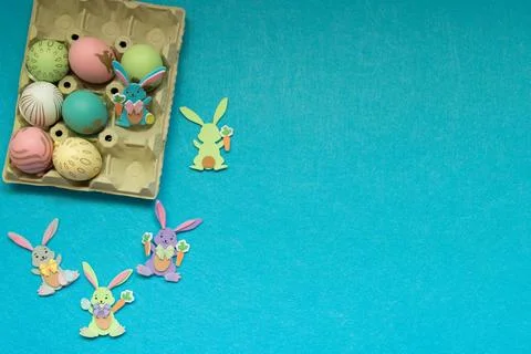 Decored easter eggs and small easter rabbits in blue background Stock Photos