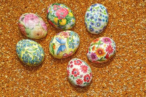 Decoupage Easter eggs on a background of scattered millet 写真素材