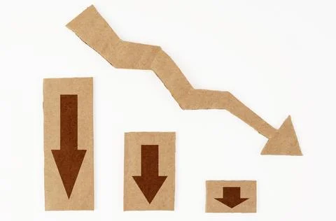 Decrease statistics concept. On a white surface is a graph and a cardboard ar 스톡 사진