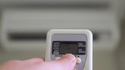Decreasing the temperature on the air conditioner with remote control. 库存影片 180586649