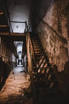 Decrepit cell block and stairs leading to upper level at Eastern State Foto stock
