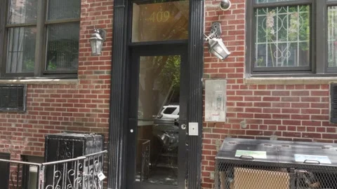 Decrepit old run down red brick brownstone building entrance with a black do Stock Footage 242365789