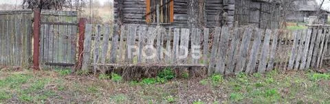 Decrepit wooden fence of the village house Stock Photos
