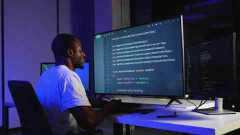 A dedicated African American software developer writes and debugs code on Stock Footage 305009581