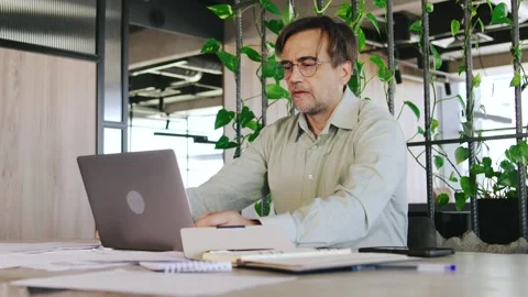 Dedicated and Focused Professional Engaged in Work on a Laptop Within a Modern Stock Footage 292640347