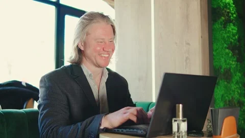 A dedicated and focused professional is seen working on a laptop in a modern Stock Footage 285087806