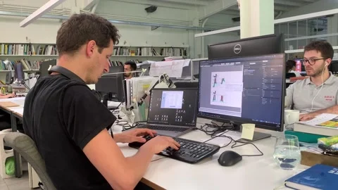 Dedicated and focused young man immersed in his work within a modern office envi Stock Footage 244487663
