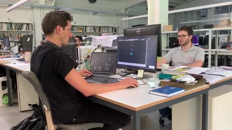Dedicated and focused young man immersed in his work within a modern office envi Stock Footage 244487664
