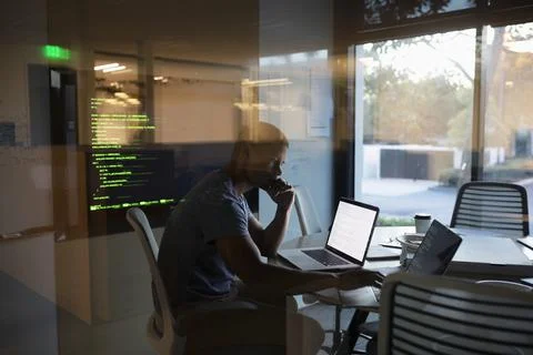 Dedicated computer programmer working at laptop in conference room Foto stock