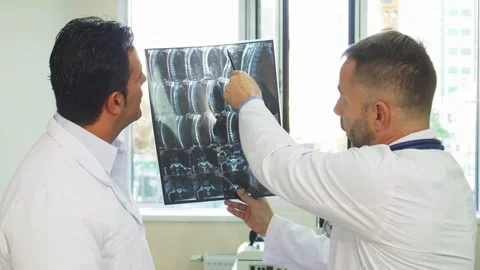 Dedicated doctors analyze a patient's X-Ray with focused attention Stock Footage 311943411