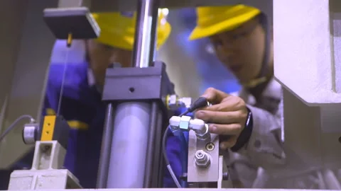 Dedicated factory workers engineer technician wearing hard hat examining and Stock Footage 347843109