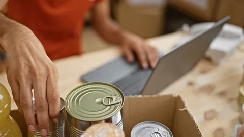 Dedicated hispanic man checking donations with laptop in charity center, vo.. Video stock 254785916