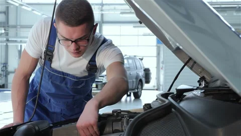 Dedicated mechanic inspecting car engine for optimal performance Video stock 311828589