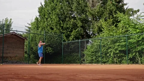 A dedicated player practices tennis skillfully on a clay court that is Video stock 313629132