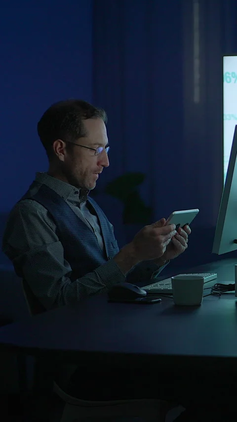 A dedicated professional is working late at night, fully engaged with Stock-Footage 296018031