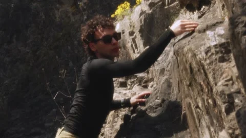 Dedicated Rock Climber in Motion: Mid-Climb Poise and Precision Captured in a Stock Footage 270531741
