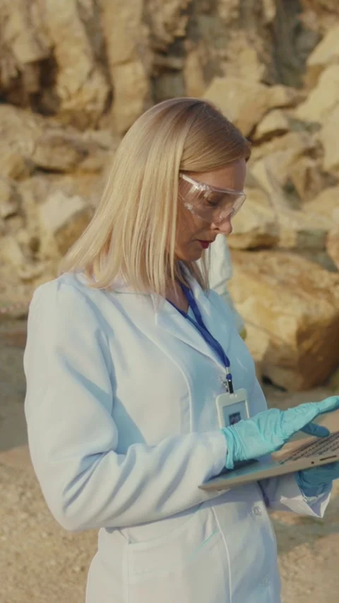 A dedicated scientist is meticulously analyzing data collected from a rocky site Stock Footage 314207572