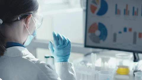 A dedicated scientist in a modern lab analyzes complex data using advanced Stock Footage 290115915