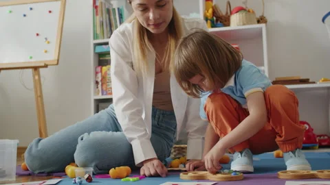 A dedicated tutor and therapist work together to empower a child's speech and Stock-Footage 264086391