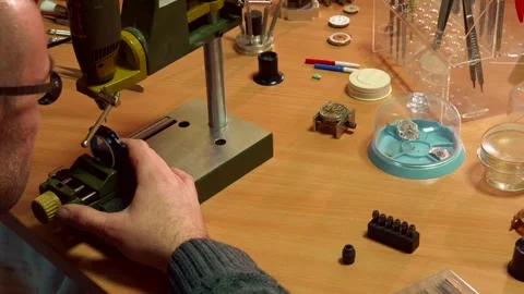 Dedicated watchmaker skillfully operates a drill press Stock Footage 311989974