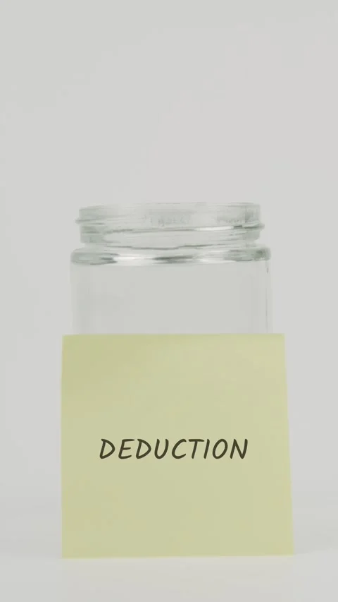 Deduction text or word on yellow sticky note attached to glass jar with hand Stock Footage 311711380
