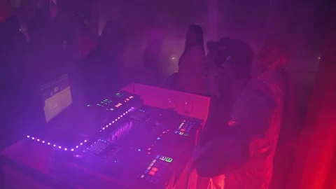 The deejay at the console who mixes during the evening wrapped in smoke Stock Footage 222556470