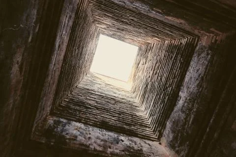 Deep ancient well. Masonry. Light at the end of the tunnel. Background. Foto stock