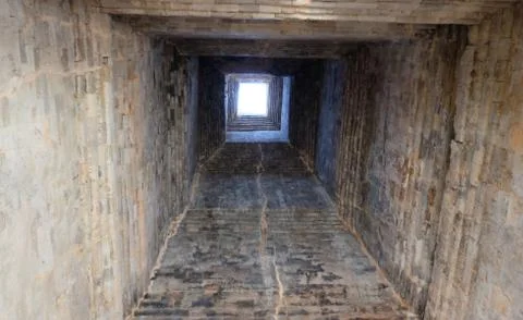 Deep ancient well. Masonry. Light at the end of the tunnel. Background. Foto stock