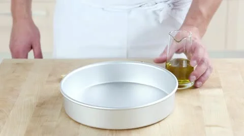 A deep baking tin being brushed with olive oil Video stock 24672492