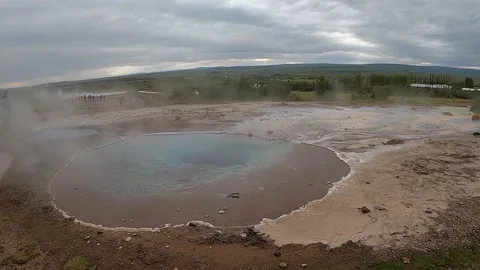 Deep blue Blesi hot spring with rising steam and tourists, Iceland Stock Footage 334948047