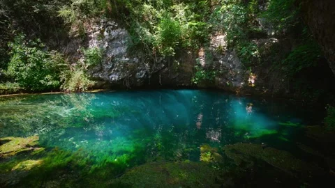 Deep blue clear spring water, limestone cave and overhanging trees at Sorgente Stock Footage 340827203