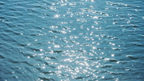 Deep Blue Lake Surface Sparkling with Light Reflections and Gentle Ripples Video stock 341868975