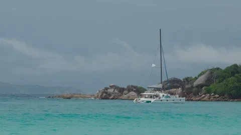 Deep blue ocean at Anse Lazio, Praslin, Seychelles, with yacht near rocky shores Видео 331505561