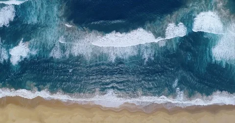 Deep blue ocean lapping against golden sandy beach aerial vertical paradise Stock Footage 87572179