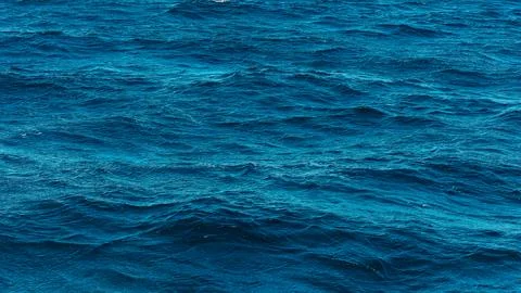 A deep blue ocean surface ripples with natural abstract textures and clear aqua  Stock Photos