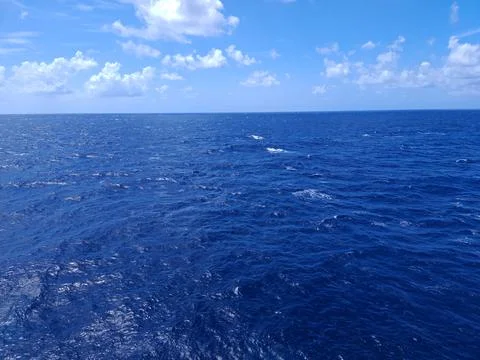 Deep blue ocean surface with whitecaps and bright blue sky with clouds. Sce.. 写真素材