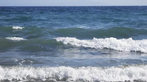 Deep blue ocean waves roll gently toward the scenic shore. Stock Footage 337412657
