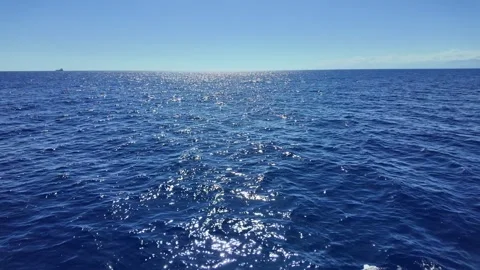 Deep blue sea with sparkling waves and distant ship on horizon Stock Footage 345268156