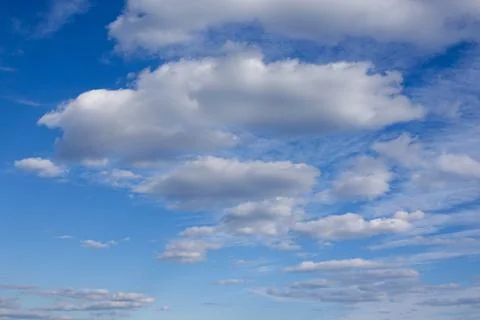 Deep blue sky behind a dramatic white puffy cloudscape Stock Photos