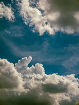 Deep Blue Sky with Dramatic White Cumulus Clouds, Vertical Nature Background Stock Photos