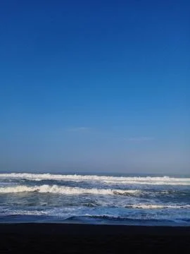 Deep blue sky meets ocean waves Stock Photos