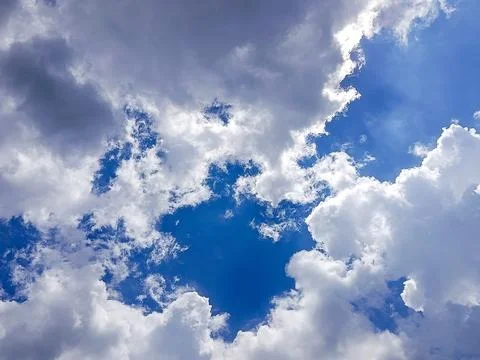 Deep Blue Sky with Thick White Clouds and Bright Sunlight Stock Photos