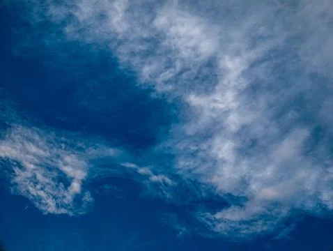 Deep Blue Sky with Wispy White Clouds Swirling Pattern, Horizontal Nature B.. Stock Photos