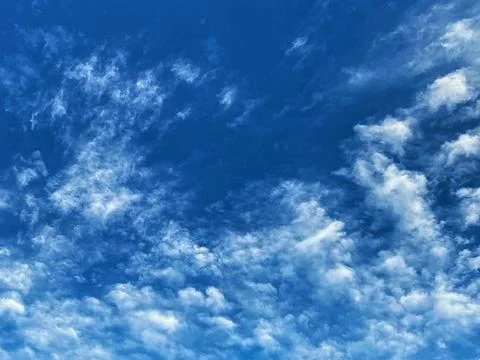 Deep blue sky with wispy white clouds Stock Photos