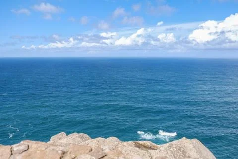 Deep blue water of calm Atlantic Ocean with clouds and blue sky. Stock Photos