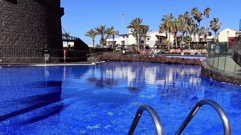 Deep blue water of pool, castillo (castle)  and beach resort in background Stock Footage 84788462