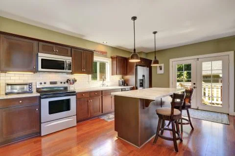 Deep Brown kitchen storage combination and bar counter with two stools. Frenc Stock Photos