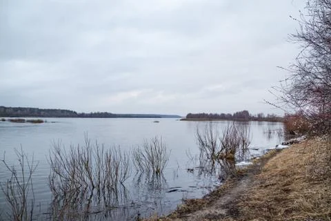 Deep calm river in the spring evening against a cloudy sky Stock Photos