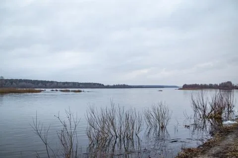 Deep calm river in the spring evening against a cloudy sky Stock Photos
