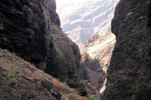 Deep canyon with steep rocky cliffs and cloudy sky Stock Photos